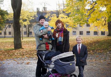 Familjeporträtt, pappa, mamma och två barn i en park på hösten.