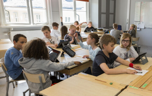 Bilden visar en skolklass som arbetar med läsplattor