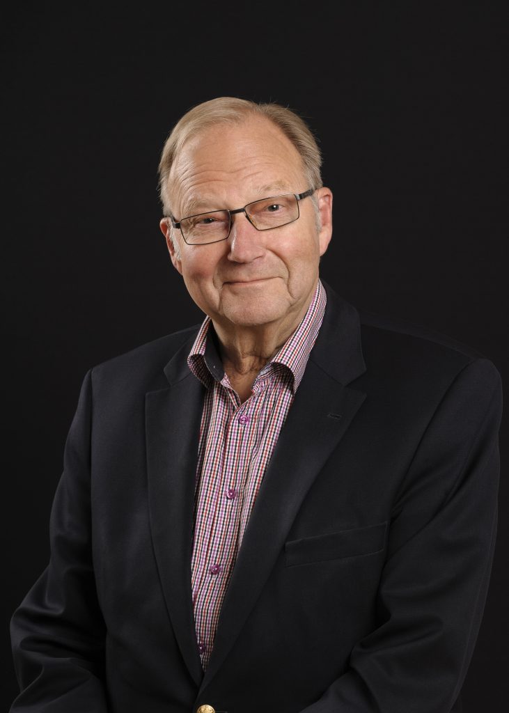 Porträttbild på man med svart kavaj och skjorta