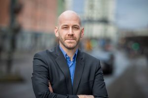 Man utomhus som tittar in i kameran