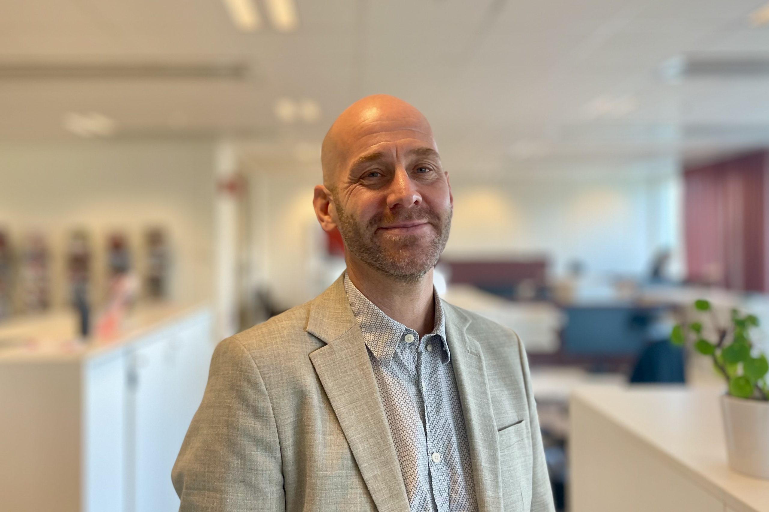 En man står i ett ljust kontorslandskap