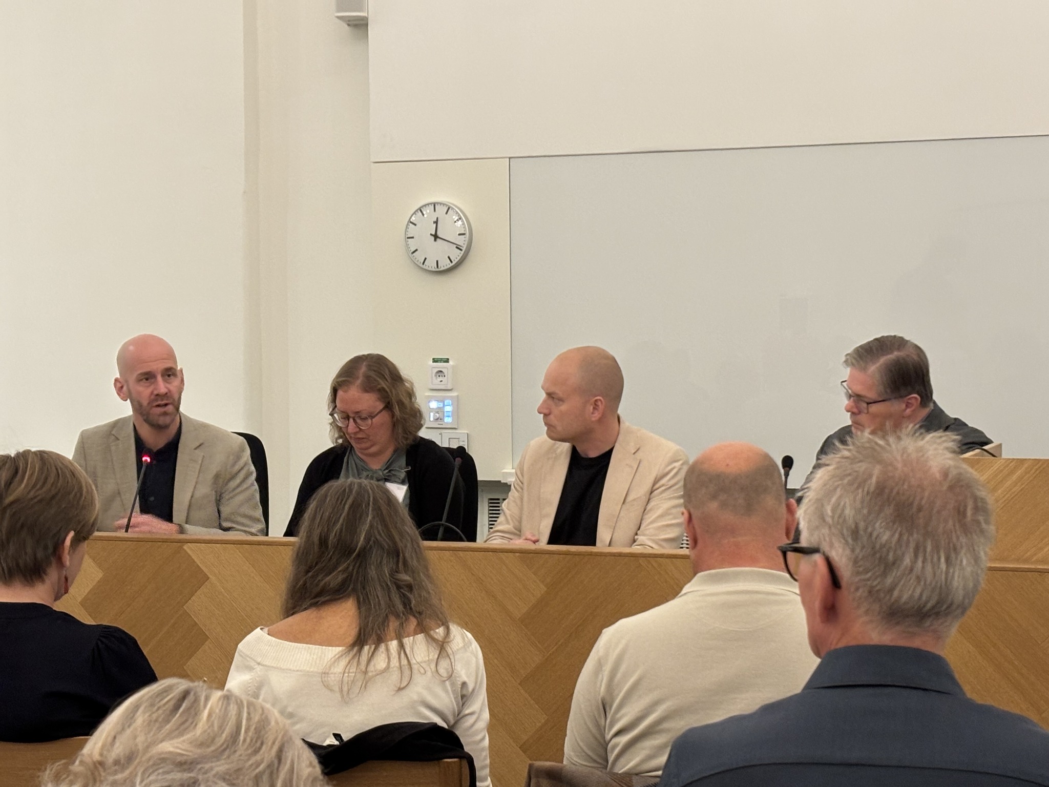 Fyra personer sitter och samtalar i ett panelsamtal