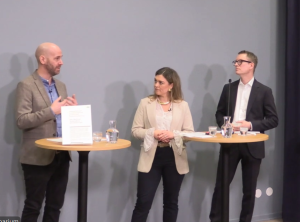 Tre personer diskuterar vid ståbord