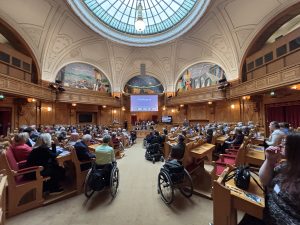 En stor sal fyllt med människor i bänkarna.