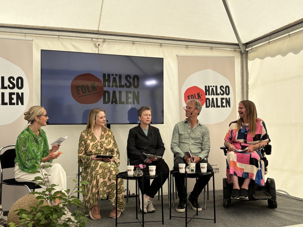 Fem personer samtalar på en scen